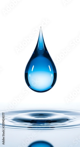 Clear blue liquid droplet descends toward a surface creating concentric ripples