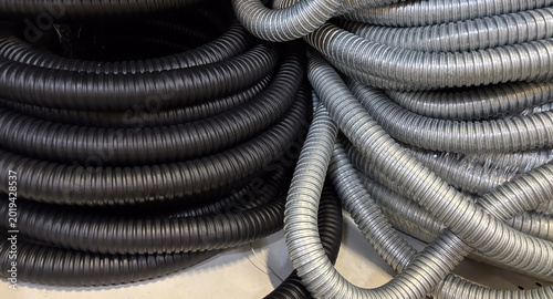 Close up of black and gray flexible corrugated hoses for industrial or plumbing protection