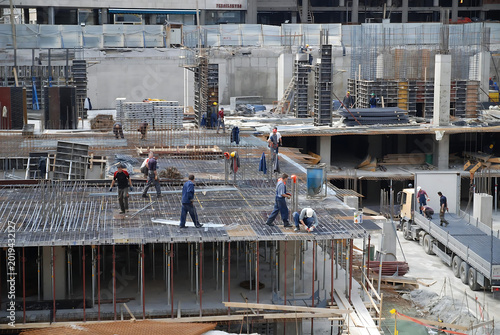 Construction workers reinforcing steel framework at industrial building site