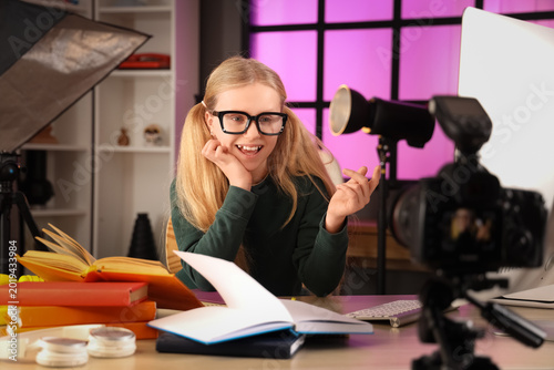 Teenage blogger studying an...