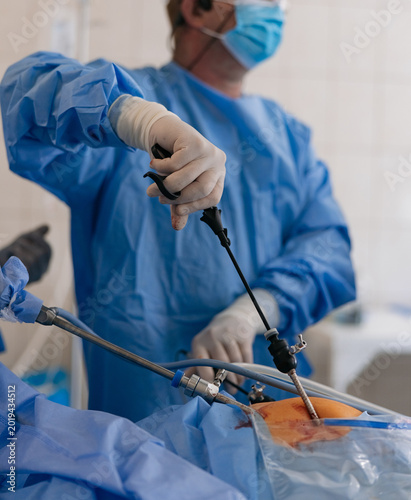 Surgeons performing laparoscopic abdominal surgery with endoscopic tools