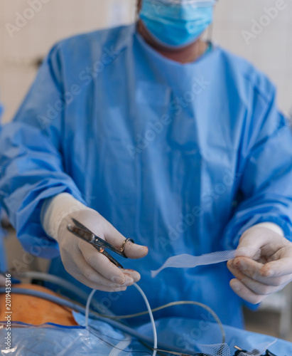 Konstfotografi Surgeon cutting surgical mesh for hernia repair surgery
