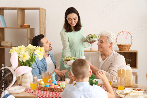 Young woman bringing salad for Easter dinner with her family at home
