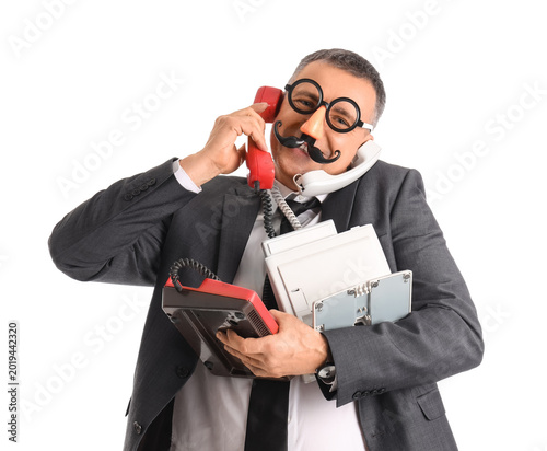 Businessman in funny disguise holding many different phones on white background