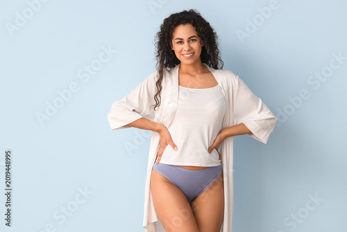 Schilderij op canvas Young African-American woman in menstrual panties on blue background