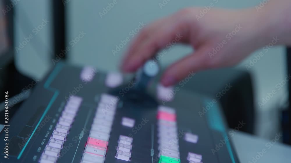 A man controlling a control panel with a green and red buttons. The ...
