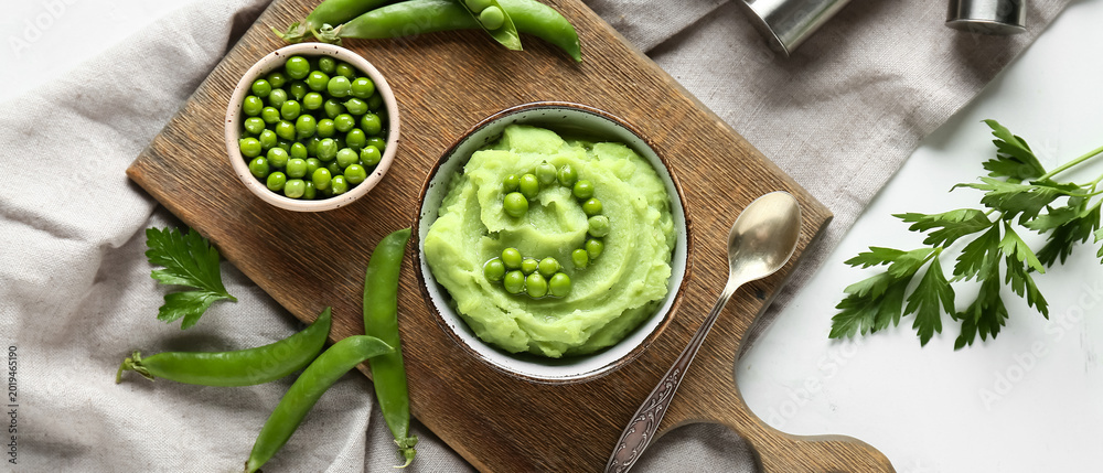 Fototapeta premium Bowl with mashed green peas and parsley on white background