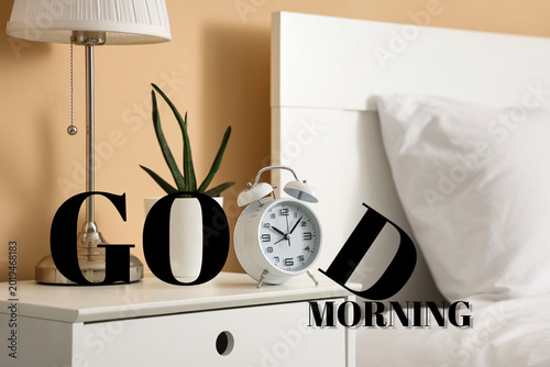 Quadro em tela Retro alarm clock with plant and lamp on table in bedroom