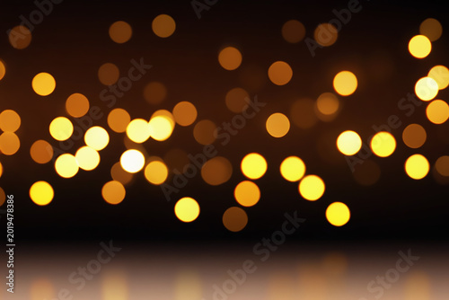 Golden Bokeh Lights Background with Reflective Surface for Festive and Celebratory Concepts