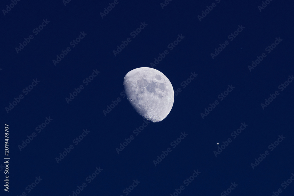 Fototapeta premium Waxing gibbous Moon and planet Venus on a daylight blue sky.