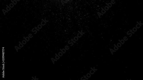 Rain drops falling in darkness on a black background. 