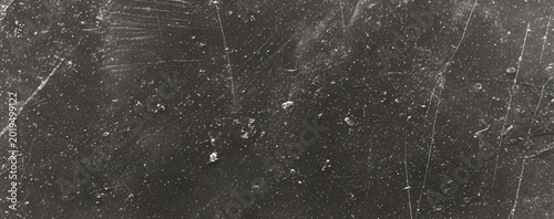 Scratched and distressed black surface with white specks and scratches