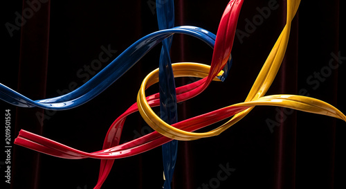 an abstract composition of glossy, hand-pulled candy (amezaiku) ribbons in deep sapphire blue, crimson, gold, elegantly twisted and frozen in motion, in a boutique window 