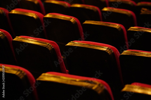 Rows of red theater seats in low light