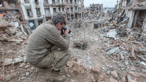War correspondent photographing the aftermath of a bombing in a destroyed city