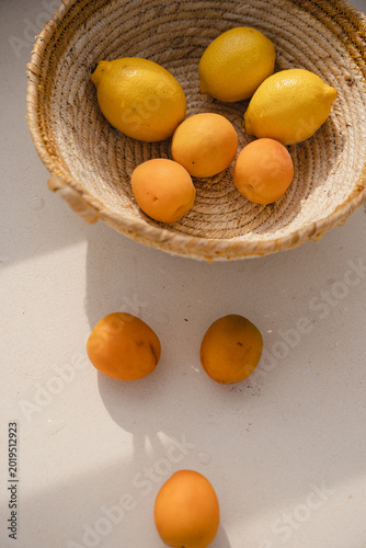 Organic Stone Fruit And Citrus Arranged In A Natural Wicker Basket On A Sunny Outdoor Table