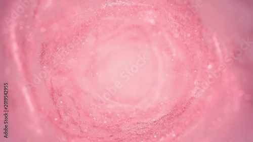 Soft pink swirling tunnel of cosmic dust and light particles creating abstract tunnel effect, cinematic motion background.