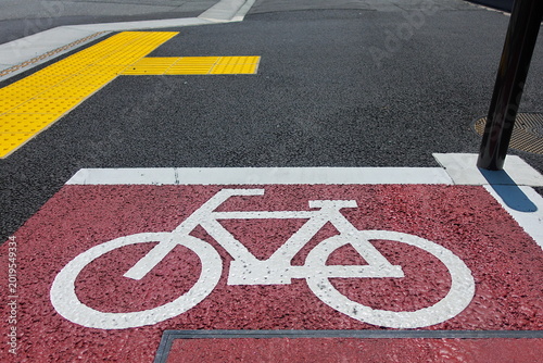 Tableau sur toile アスファルト道路に描かれた赤色の自転車専用レーン標示。改正道路交通法による罰則強化と交通安全のイメージ。