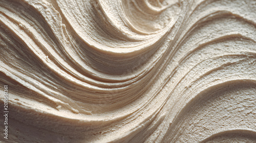 Thick beige cosmetic cream or dessert frosting creating an abstract swirl pattern, showcasing smooth texture, luxurious softness, and fluid movement perfect for beauty or food concepts