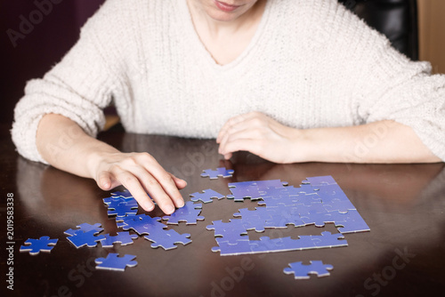 Canvastavla Woman working on a puzzle with scattered pieces on the table