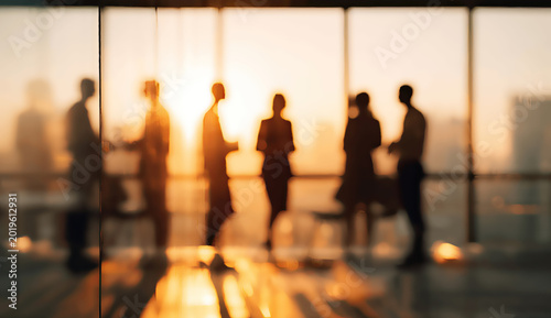 Silhouettes of professionals in a sunlit office meeting, warm glow, city view