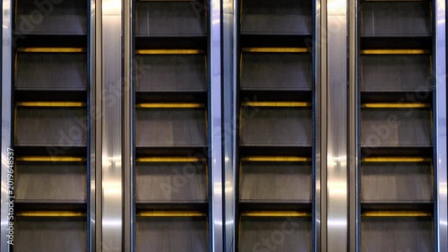 the steps of an empty escalator move up close up view from above