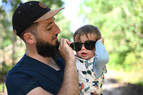 Foto young child in the arms of his bearded father