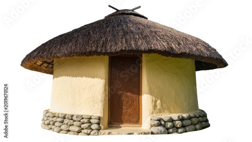 Fotografía Round thatched roof hut with stone base and wooden door, isolated on transparent