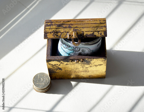 A wooden chest containing coins and Russian rubles. The concept of capital accumulation and growth.