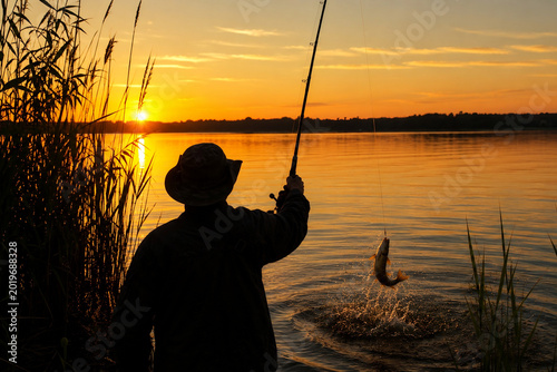 Fisherman Catching Fish at Sunset on the Lake