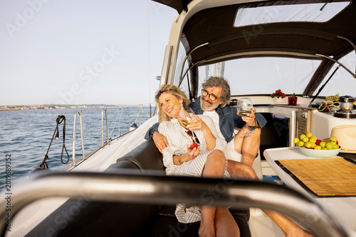 Quadro su tela Mature couple enjoying wine on sailing boat, relaxing outdoors