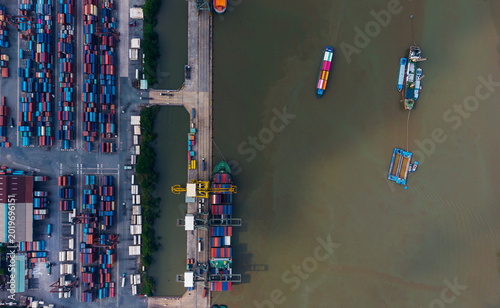 Aerial top view of cargo port and vessels with stacked containers for logistics background and transport infrastructure