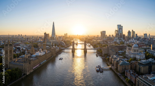 Panoramic aerial view of London skyline at sunrise with the River Thames and Tower Bridge.