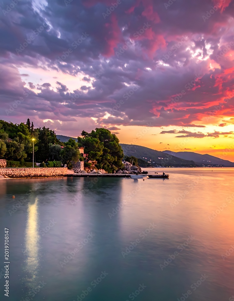 Obraz premium Serene lake at sunset with mountains.