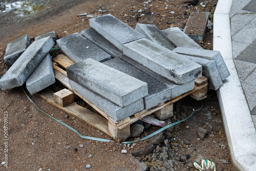 Construction waste cleanup. Pile of discarded paving and building materials for salvage. Unused paving stones and construction waste gathered for potential recycling and repurposing