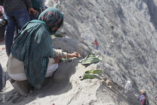 Принти на полотні A Tenggerese woman offering prayers and incense at the edge of Mount Bromo crater, Indonesia