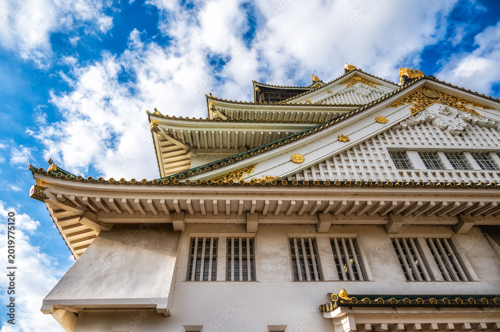 Fototapeta premium Upward low angle view of Osaka Castle rooflines and gilded shachihoko,