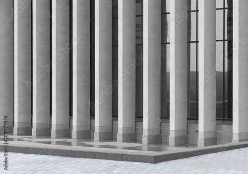 Modern building facade with tall columns and dark windows. Monochrome architectural exterior with clean vertical lines. Urban real estate and commercial property background..