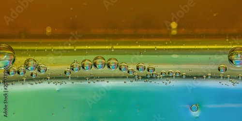Oil bubbles floating in water separating liquid layers