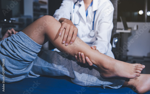 Rehabilitation therapy Professional male physiotherapists working in rehabilitation centers while treating male patients with leg and muscle pain.