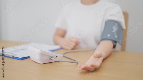 woman checking Blood pressure by Blood pressure monitor with Cuff. Systolic, SYS, Diastolic, DIA, Pulse, Hypertension, Hypotension, Heart rate, Cardiovascular Disease and May World hypertension day
