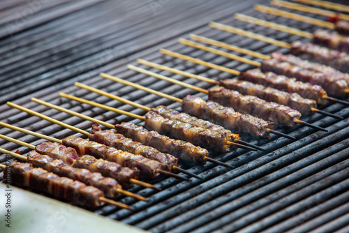 Arrosticini mutton skewers grilling on charcoal barbecue