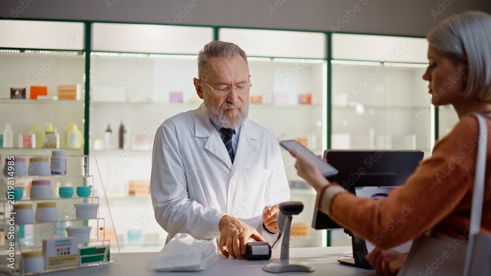 Fototapeta premium Pharmacy worker typing terminal closeup. Lady buying medicine paying smartphone