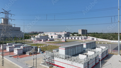 Fotografie Outdoor energy storage container array at a substation under clear blue sky