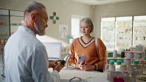 Foto Pharmacy visitor paying smartphone buying medicine closeup