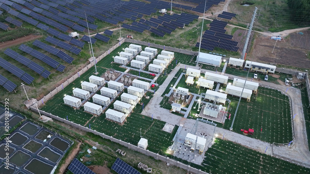 Fototapeta premium Photovoltaic power station with energy storage containers and solar panel arrays