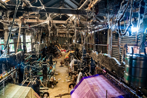 Inside a looming factory in Araihazar village, workers operate machines and produce textiles during the day while dust settles in the air