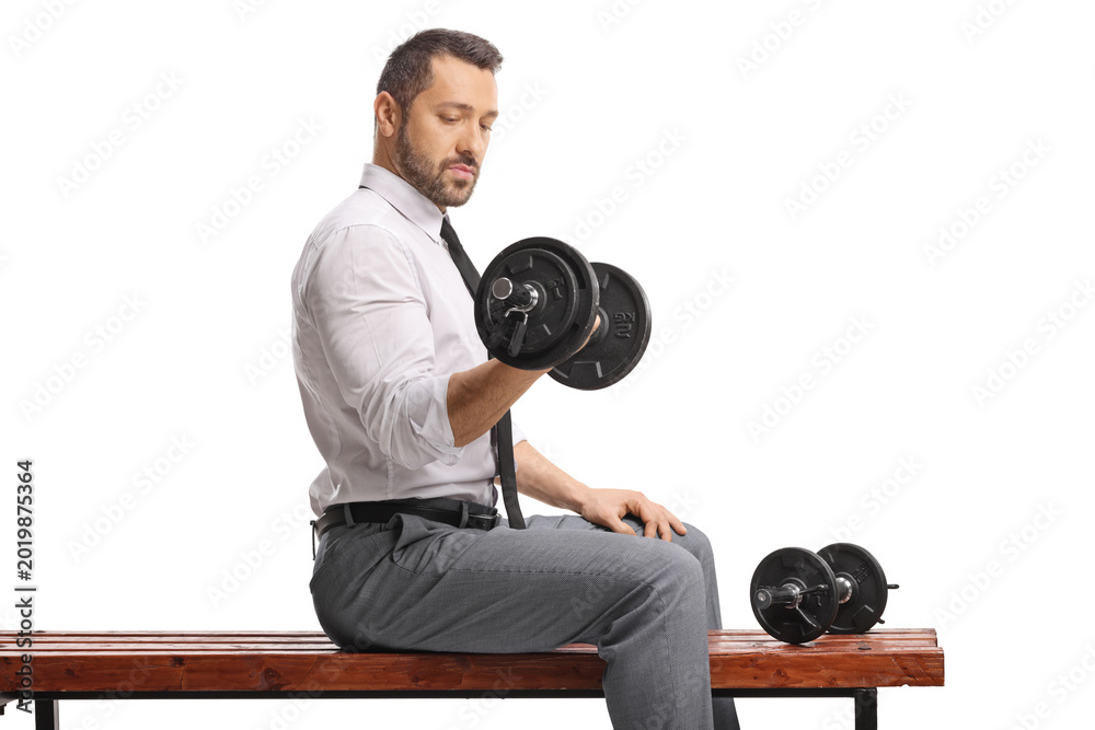 Fototapeta premium Businessman in a shirt and tie lifting a dumbbell on a wooden bench