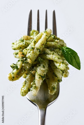 Trofie Pasta with Genovese Basil Pesto Sauce Pine Nuts Fresh Basil Leaf on Silver Fork Italian Macro Photography