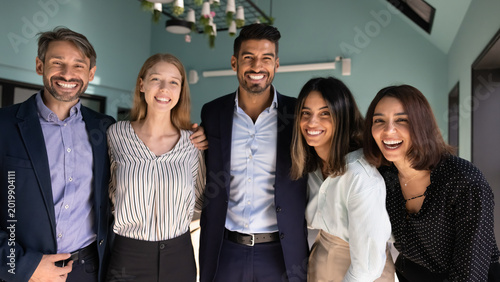 Foto Multiethnic corporate team members posing for portrait in office, laughing, look